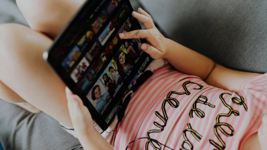 A young child picking a movie to watch using a fast, reliable and affordable internet connection