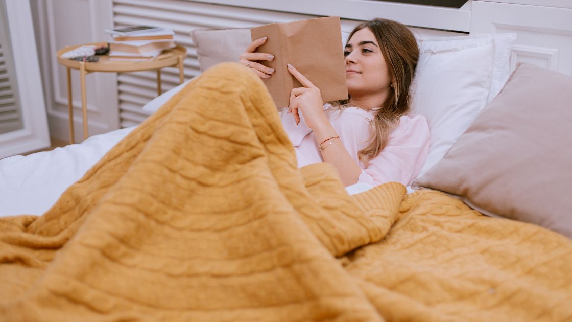 Woman reading a book in bed |#WifiProviders